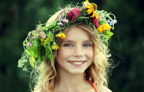маленькая красивая девочка с венком из цветков на голове